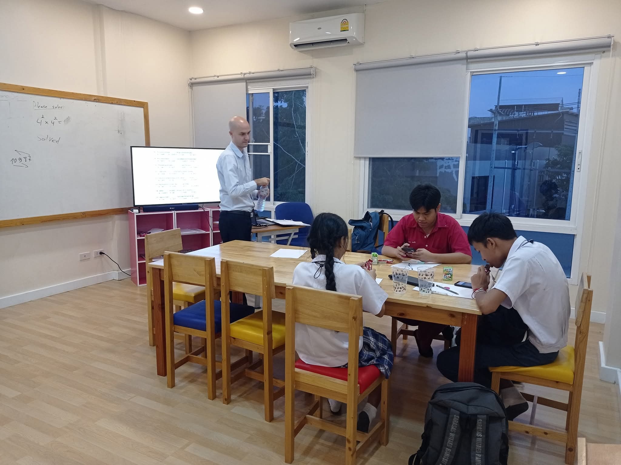 Volunteer teacher with children at a rural school in Thailand
